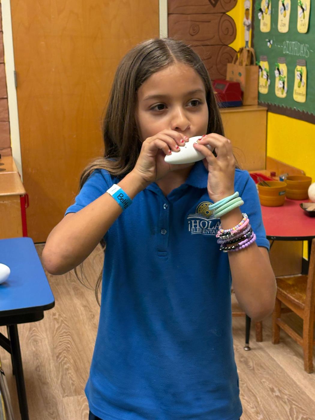 A student plays a white 3D-printed ocarina.