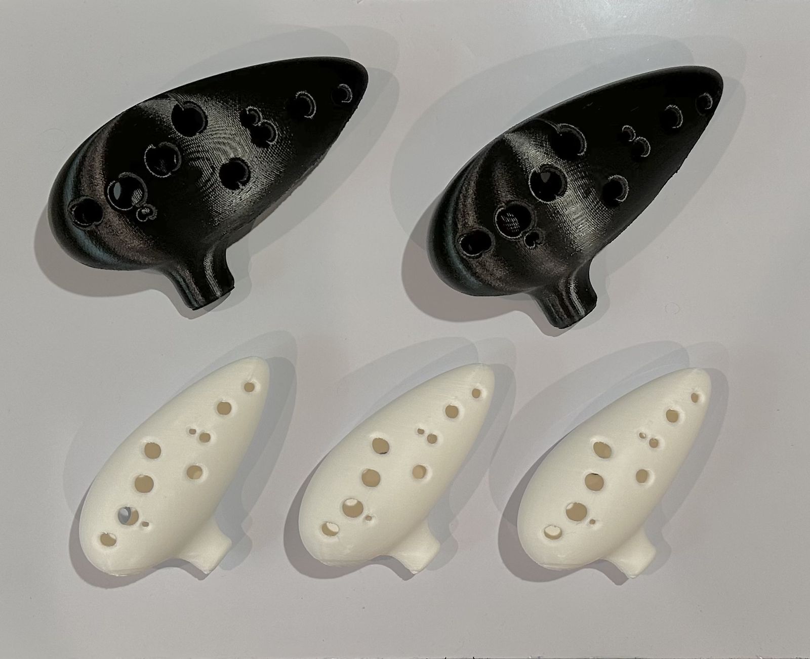 3D-printed ocarinas in black and white finishes.